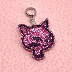 Pink glittery cat-shaped pendant on a pink textured background